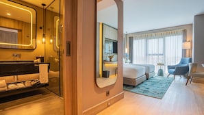 Une chambre d’hôtel moderne comprenant une salle de bain, un espace de vie et une chambre à coucher.