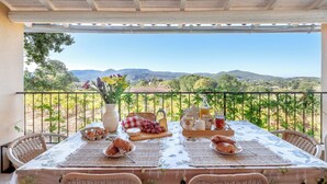 Una mesa lista para el desayuno con vistas a montañas y follaje.