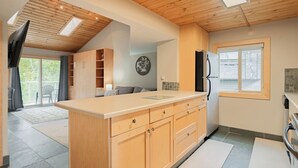 Una cocina moderna con armarios de madera, una isla central y un refrigerador empotrado.