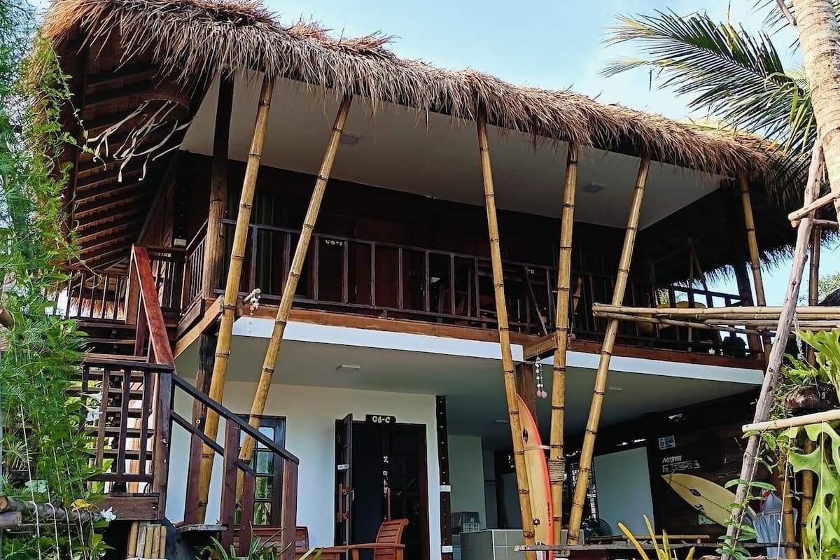 A two-story building with a thatched roof and bamboo pillars.