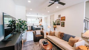 A modern living room with a sofa, coffee table, and television. - Upscale 2BR Apartment by MHM Luxury Properties (Athens)