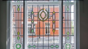 A room with a large window featuring a decorative stained glass design. - Contemporary 1BR Gem | Elysée Suites, Southport (Southport)
