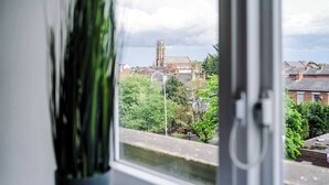 A view through a window with a building in the background, including a tower-like structure.