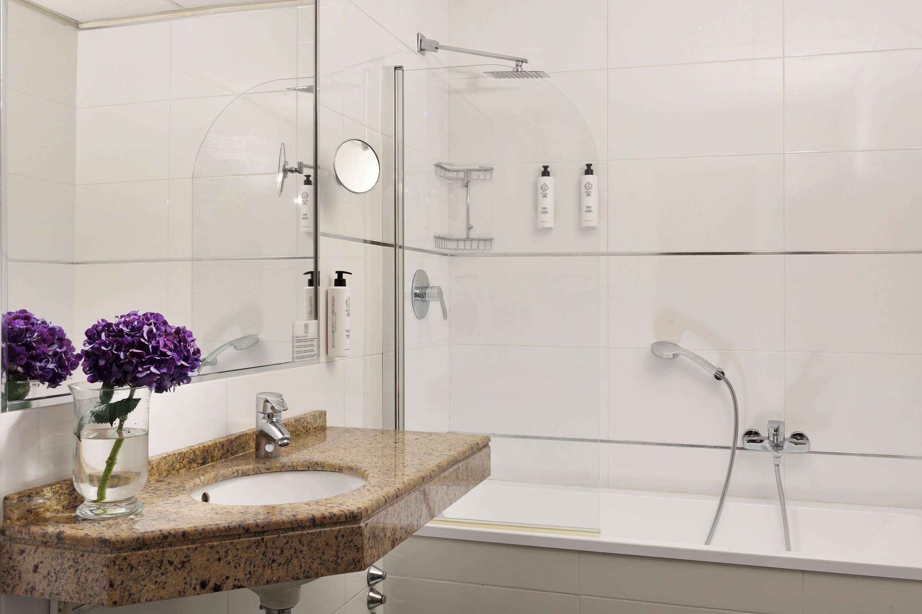A bathroom with a granite countertop sink, a mirror, a glass shower enclosure, and a bathtub.