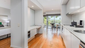 Cozinha moderna com área de refeições, uma pequena copa e vista para o exterior.