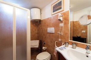 Ein Badezimmer mit Toilette, Waschbecken, Handtuchhalter und Spiegel.