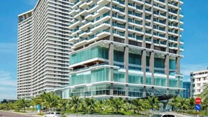 Un edificio moderno de gran altura con varios balcones y fachada de vidrio.