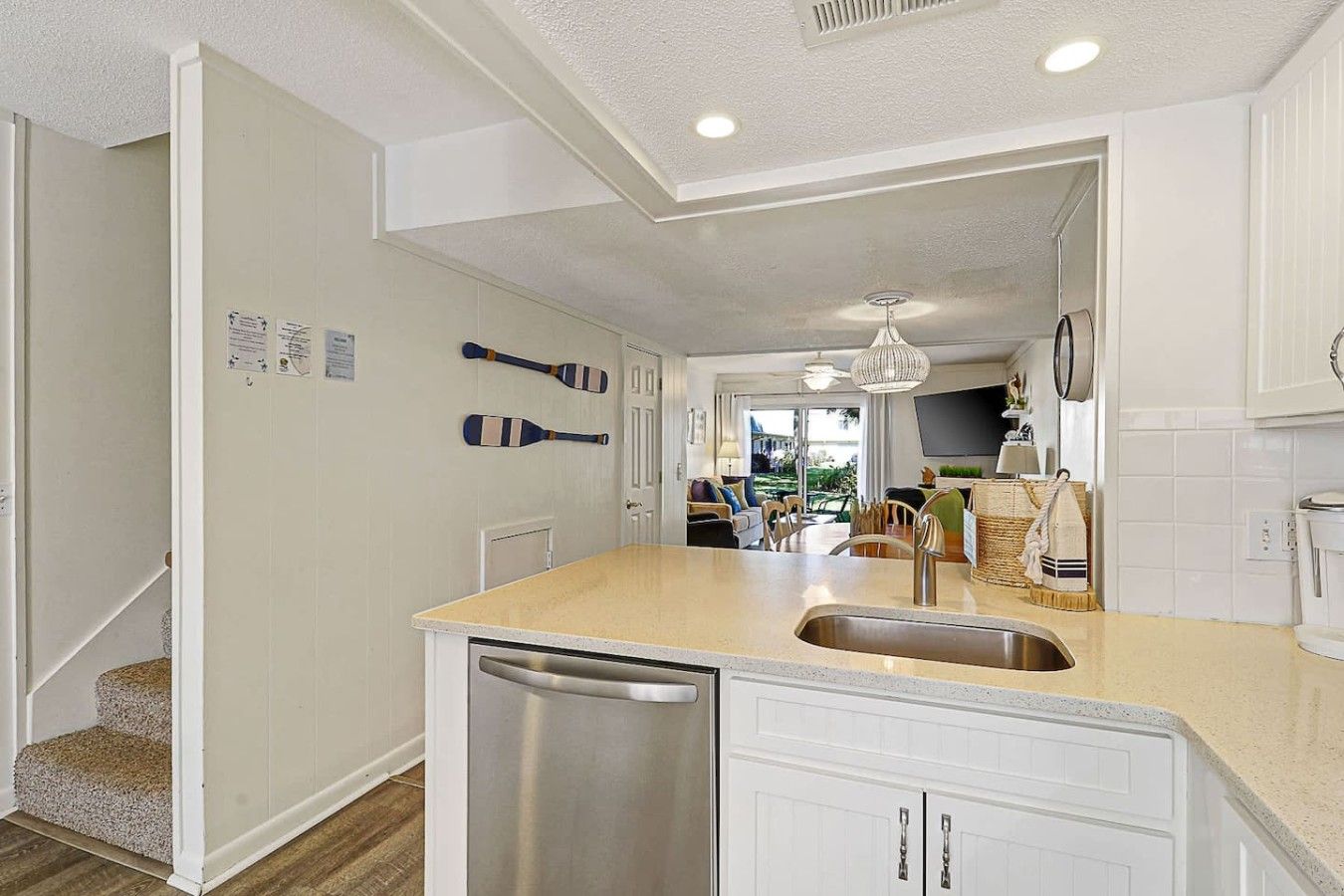A modern kitchen with a central island, stainless steel appliances, and a view into the dining area.