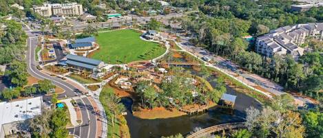 Luchtbeeld van een resort met een centraal waterpartij, aangesloten wegen en omliggende groen.