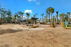 A paved plaza with palm trees, a gazebo, and a sign for the Discovery Trail.