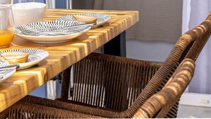 Une table de petit-déjeuner avec des assiettes, des verres et un saladier de fruits.