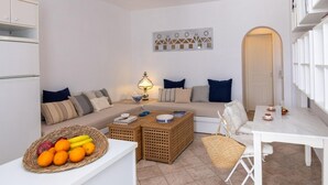 A modern living room with a sofa, coffee table, and a dining area. - Akrotiri Tinos Town (Tinos)
