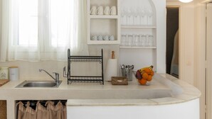 A kitchen with a sink, a wine rack, and a fruit bowl. - Cycladic Vibes Tinos (Tinos)