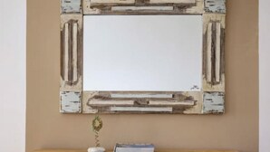 A wooden desk with a white mirror above it, two white lanterns on the floor, and a small decorative item on the desk. - Ballos for 4 in Exomvourgo (Tinos)