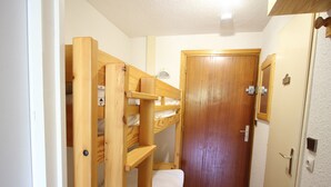 A compact room with a wooden bunk bed, a door, and a small window. - Cozy studio with balcony and pets allowed in Chamrousse (Chamrousse)