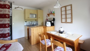 A compact kitchen with a microwave, coffee maker, and wooden cabinets. - Cozy studio with balcony and pets allowed in Chamrousse (Chamrousse)