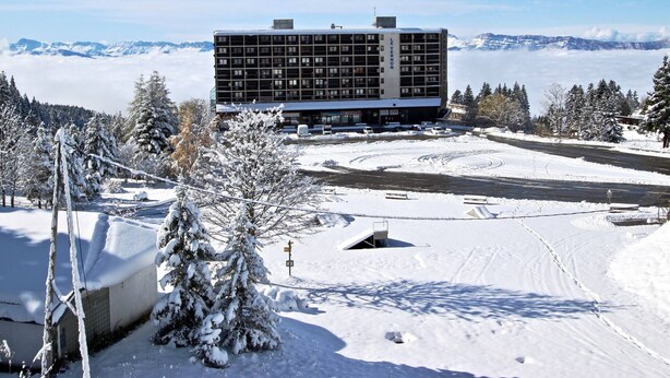 A multi-story hotel with a modern design, surrounded by snow-covered landscape and mountains in the background. - Cozy studio with balcony and pets allowed in Chamrousse (Chamrousse)