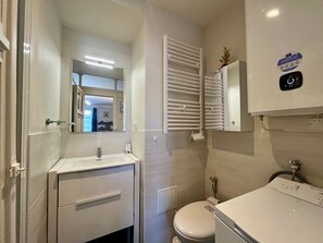 Ein modernes Badezimmer mit Waschbecken, Toilette und Handtuchhalter.
