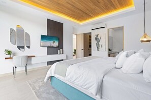 A modern bedroom with a large bed, a TV mounted on the wall, and a ceiling with integrated lighting. - Villa Tropical Dawn (Bosques de Pinilla 10, Hacienda Pinilla)