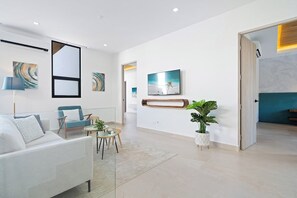 A modern living room with a sofa, chairs, a coffee table, and artwork on the walls.