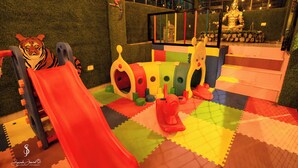 A play area with a slide, a climbing structure, and a colorful play mat.