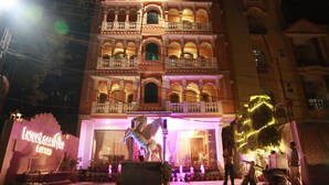 A multi-story hotel with balconies and a central entrance.