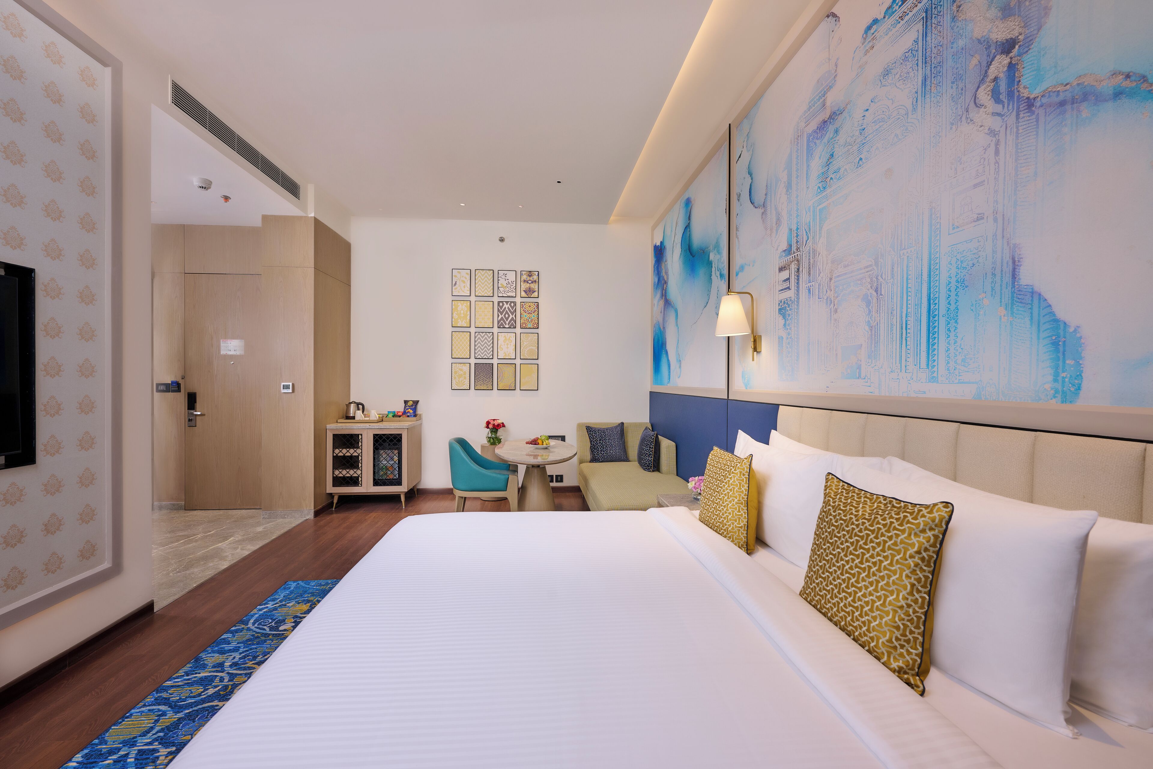 Une chambre d’hôtel avec un grand lit, un canapé, une petite table et un téléviseur.