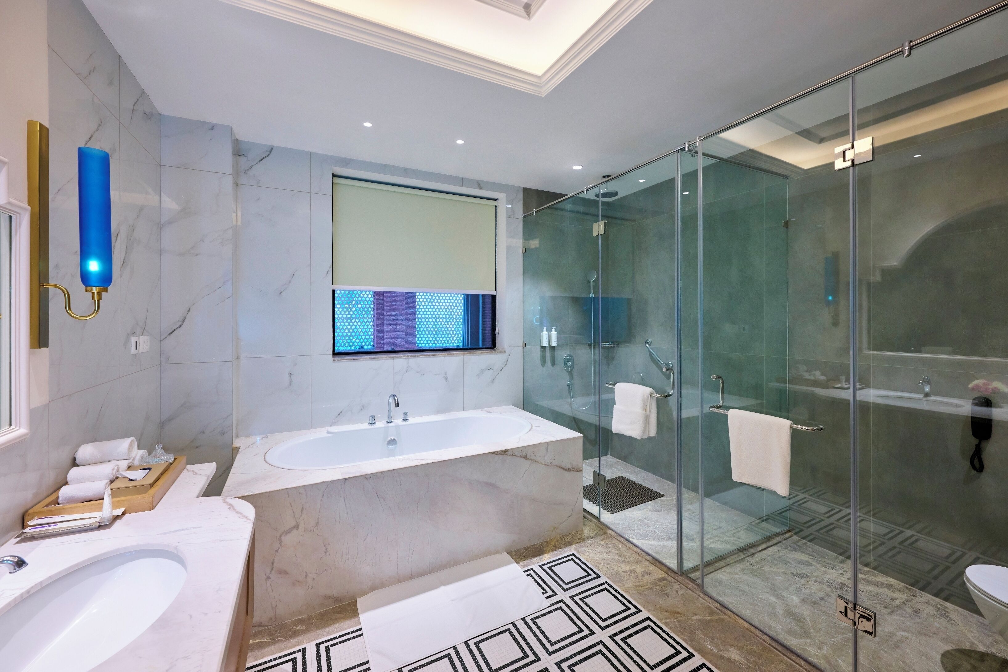 A modern bathroom with a large bathtub, a glass-enclosed shower, and a vanity with a mirror.