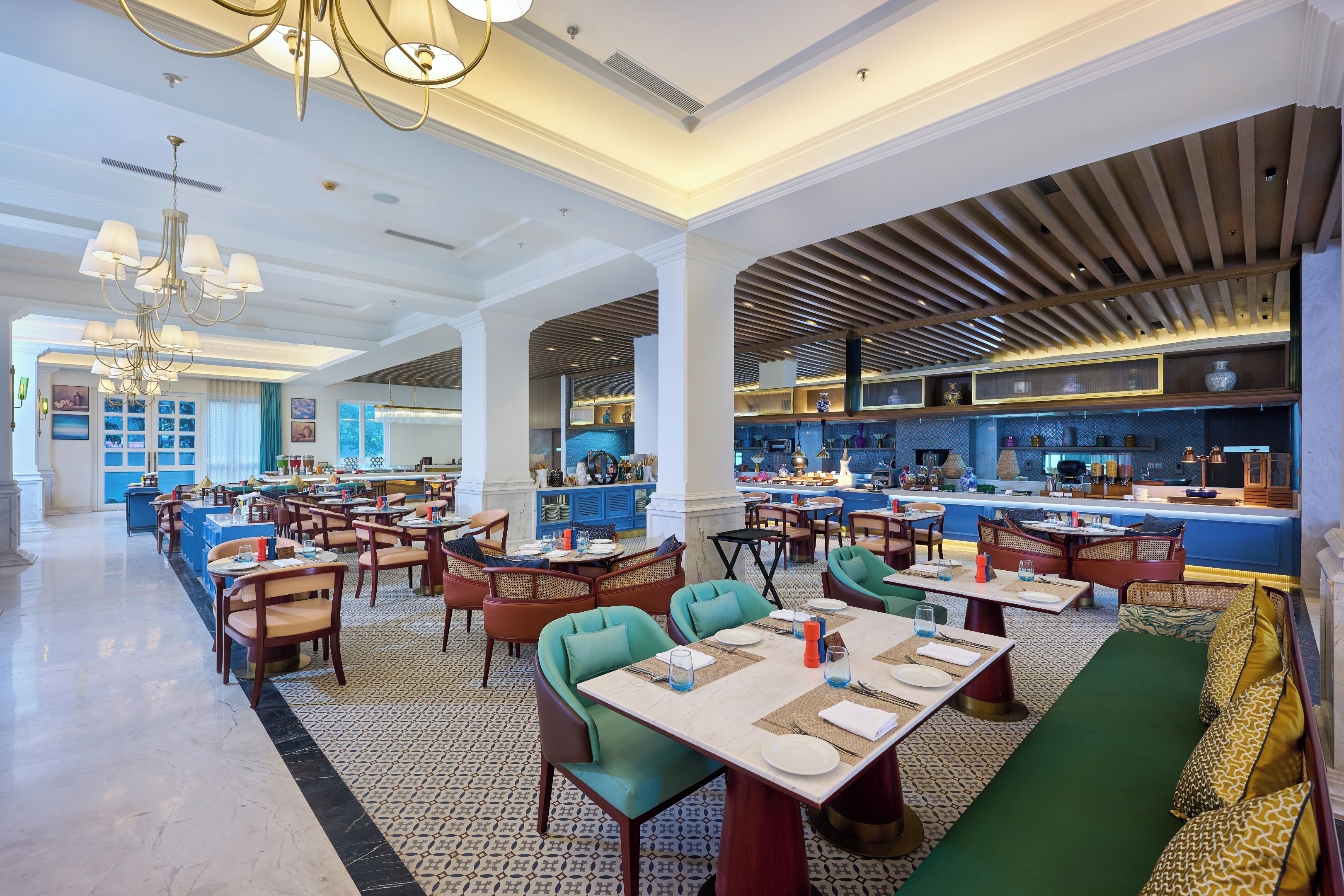 A spacious restaurant with high ceilings, chandeliers, and a variety of seating options including tables and booths.