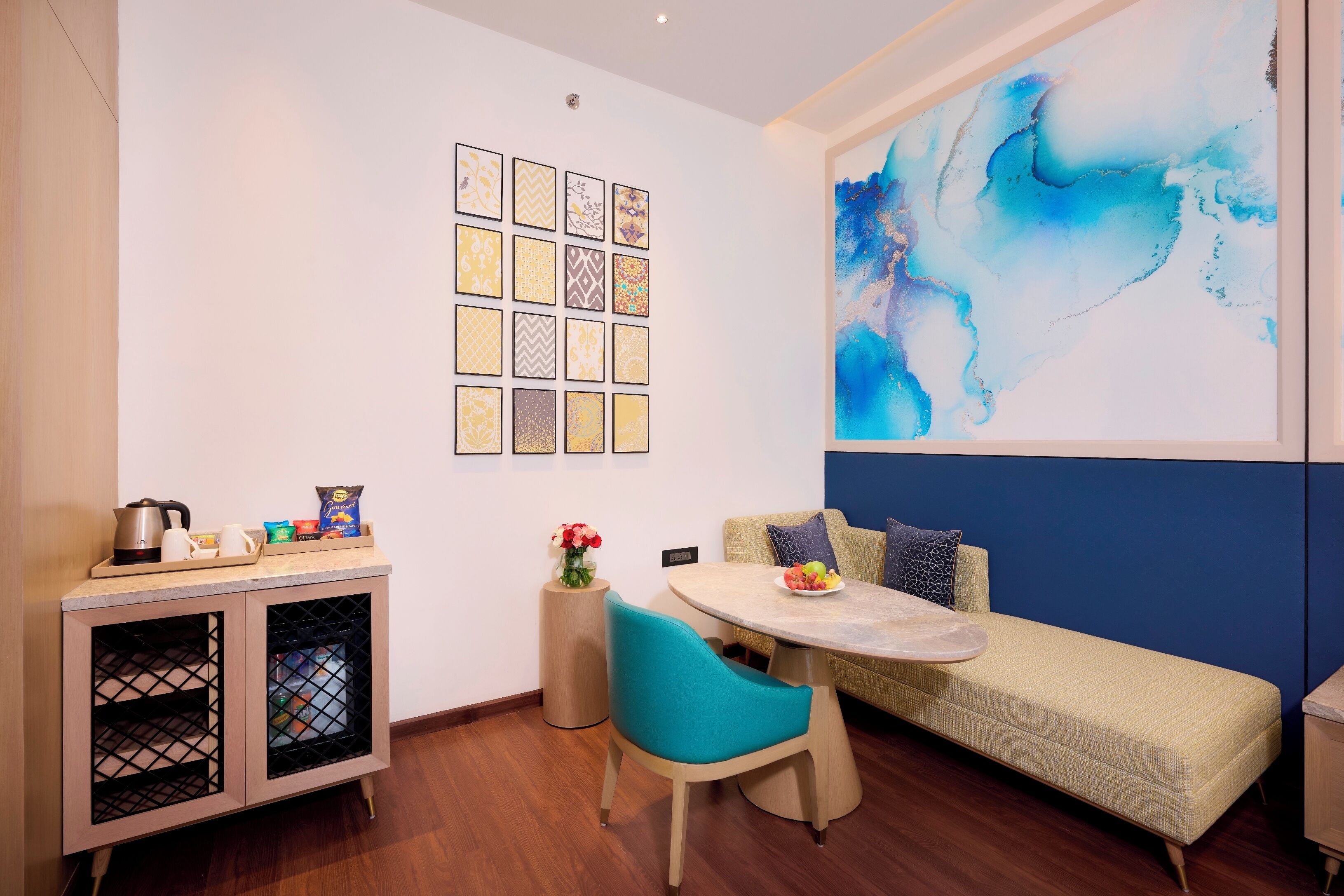 A compact living space with a sofa, a dining table, and a cabinet with a small kitchen setup.