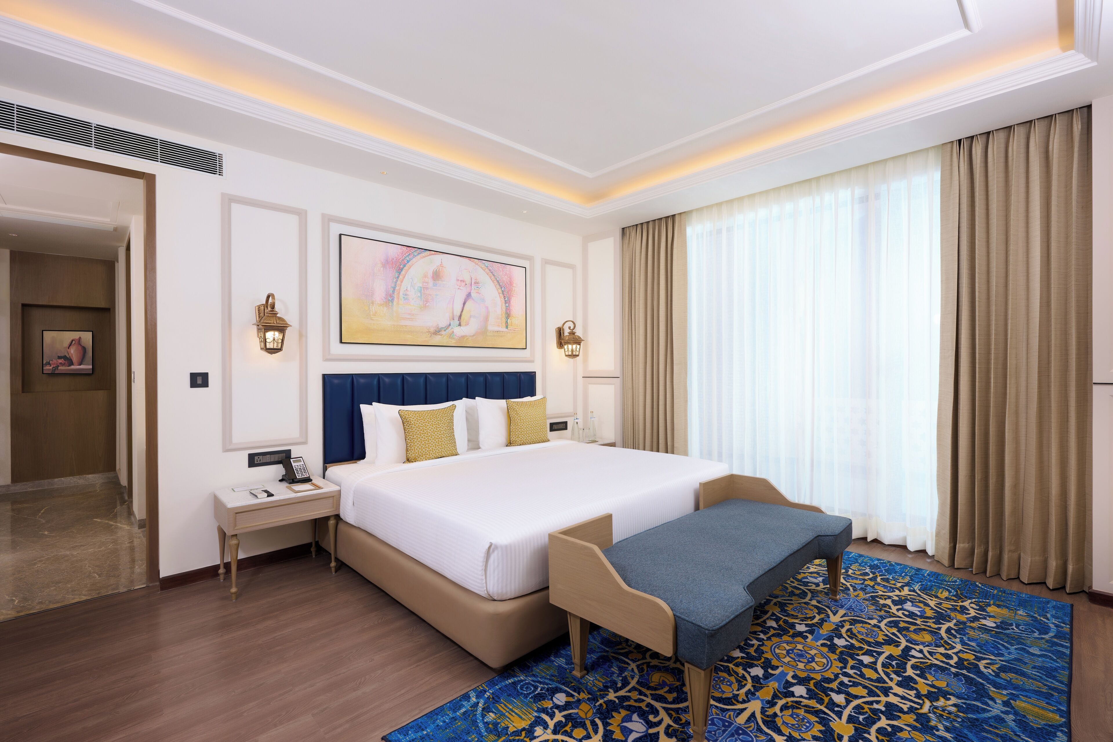A hotel room with a large bed, bedside tables, a desk, and a chair.