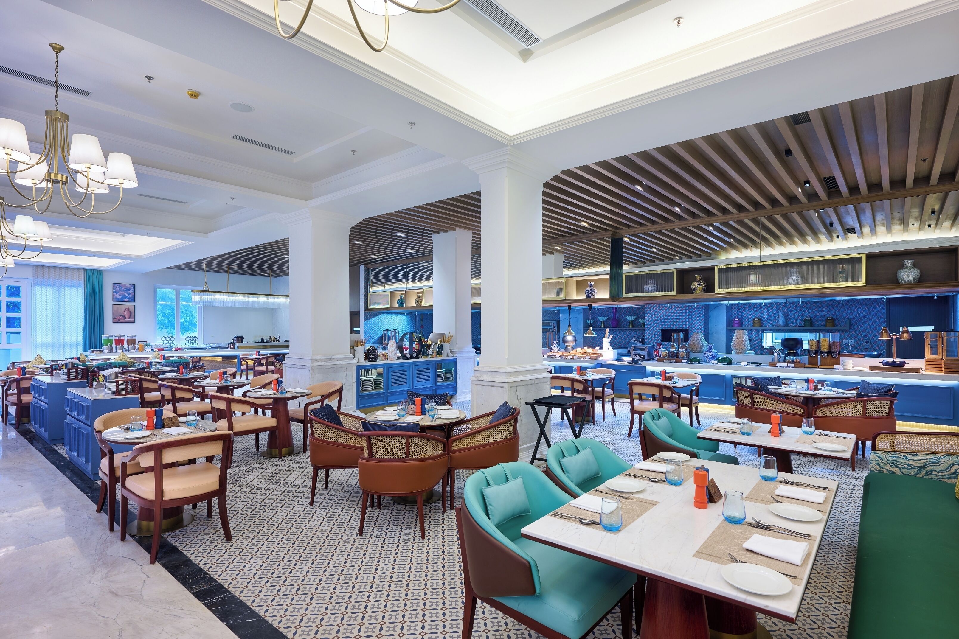 A spacious restaurant with multiple dining areas, a central bar, and a modern ceiling design.