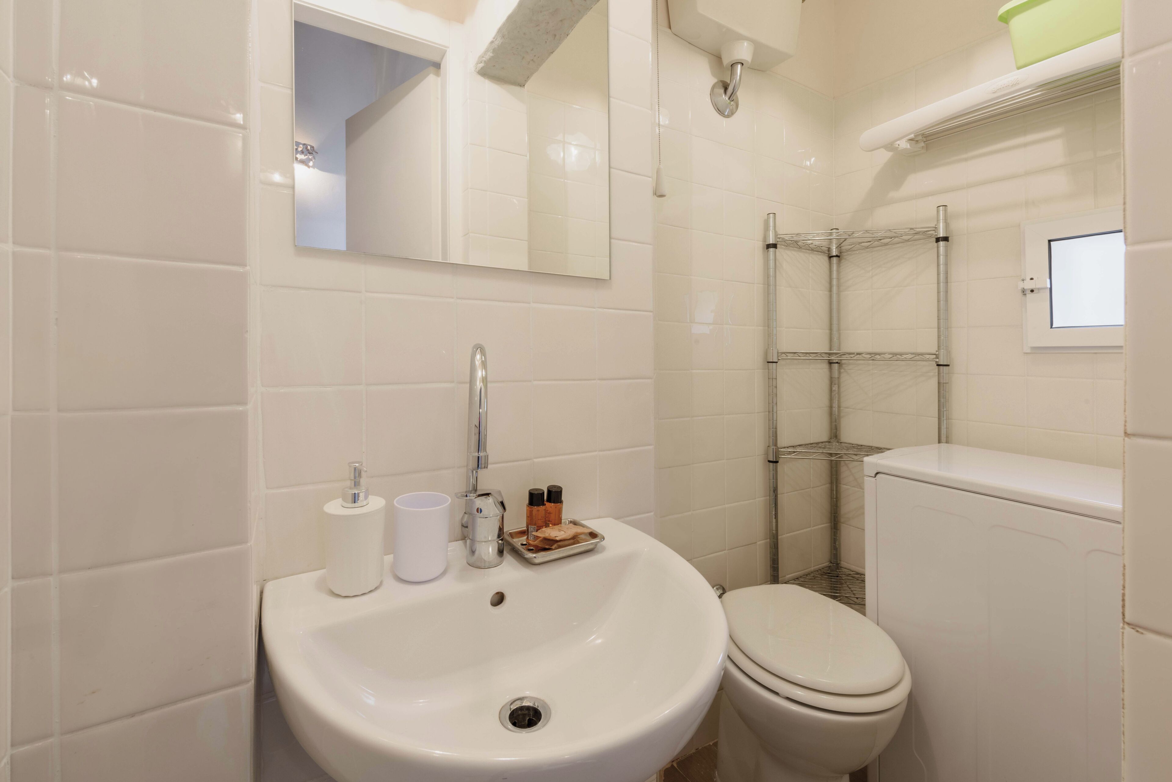 A bathroom with a sink, toilet, and a shower area.
