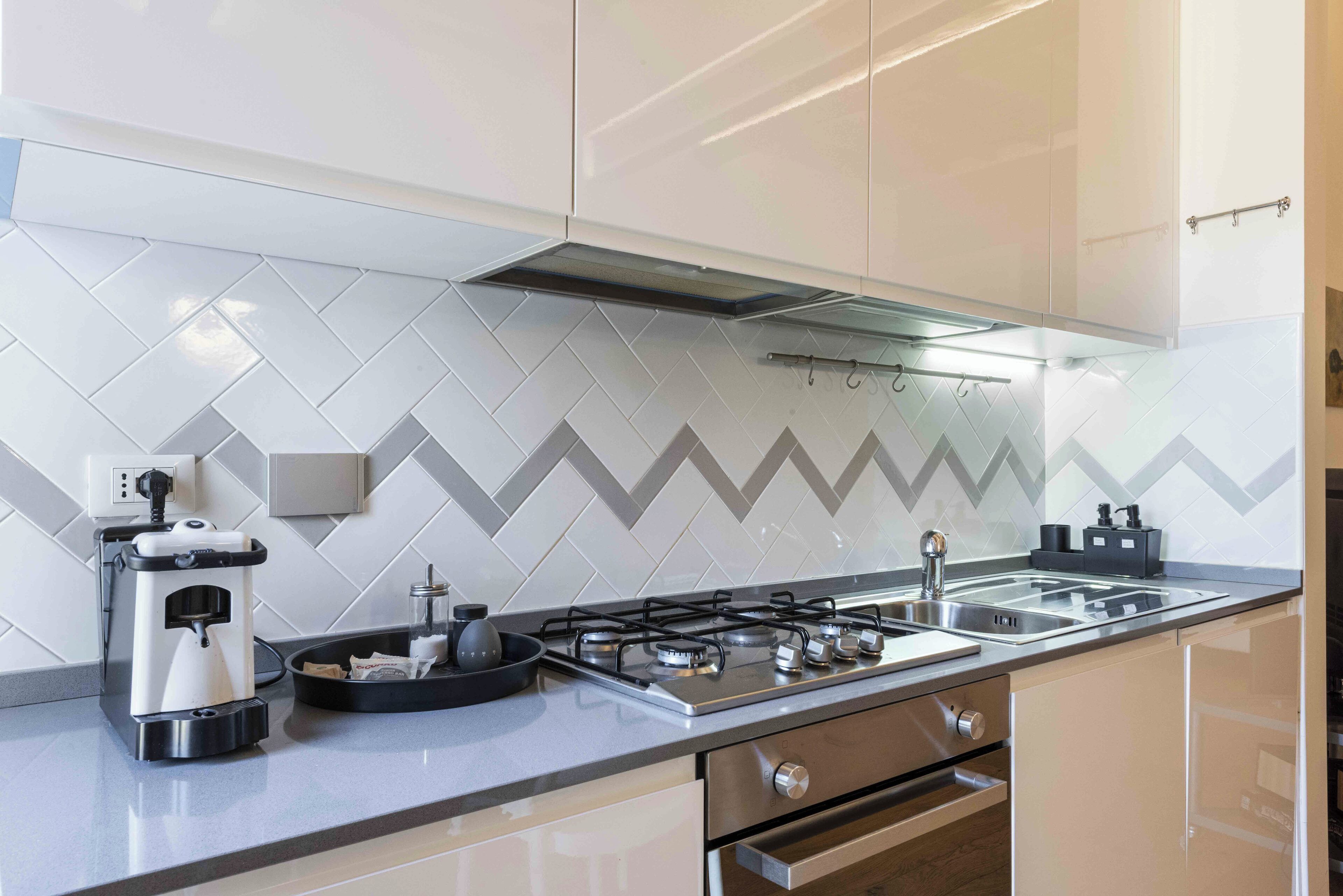 A modern kitchen with a gas stove, coffee maker, and a microwave.