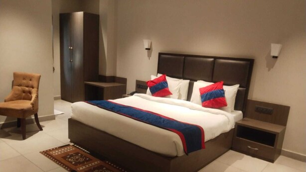 Una camera da letto moderna con un letto grande, un comodino, una sedia e una porta.