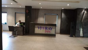 Una reception con una insegna che riporta "VI RAY INN" e una sveglia sopra.