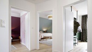 A hotel room with a bed, bedside table, lamp, and a wardrobe.