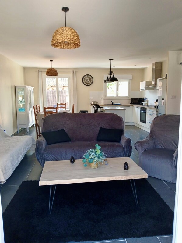 A modern living room with a sofa set, a coffee table, and a dining area with chairs and a cabinet. - House with pool and garden (Salses-le-Château)