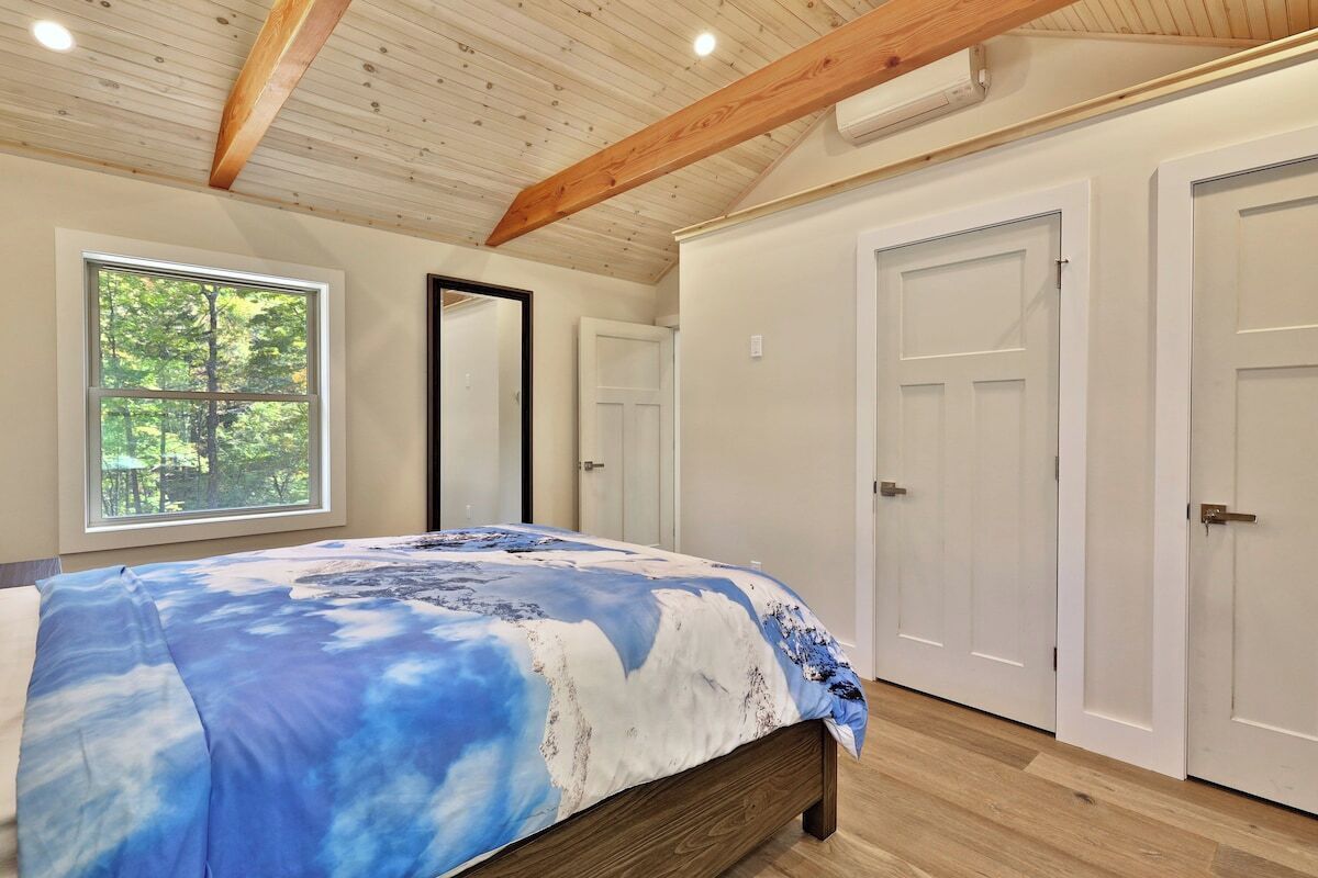 A bedroom with a bed, a window, and a door.