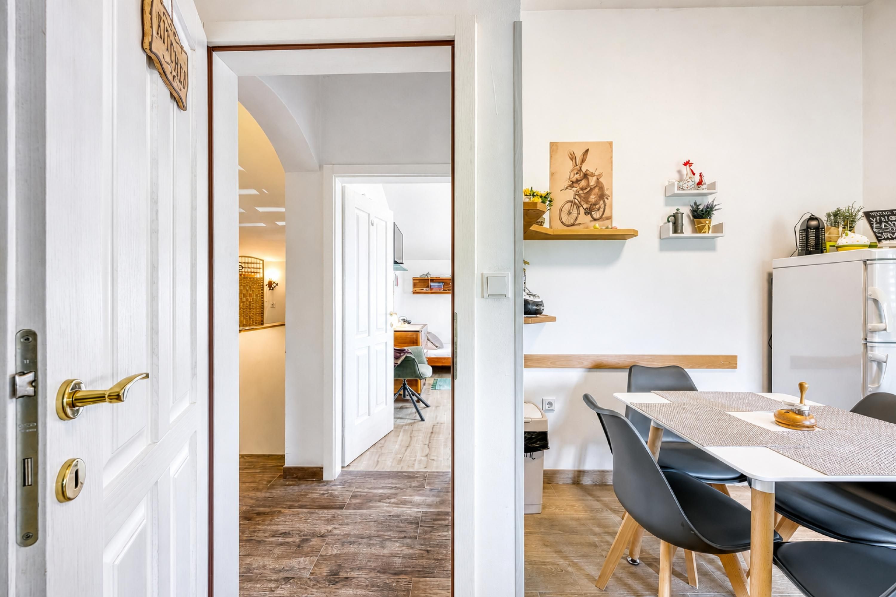 A dining area with a table, chairs, and a kitchen in the background.