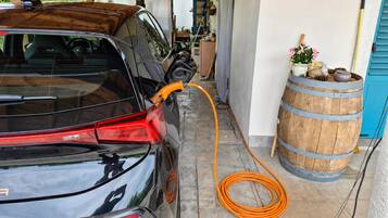 A car parked inside a garage with a charging cable connected to it.