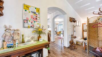 A room with a sewing machine, a bulletin board, and a wicker chair.