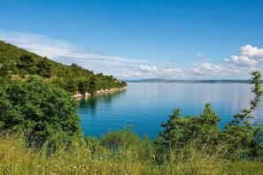 A serene lakeside view with lush greenery and a clear sky.