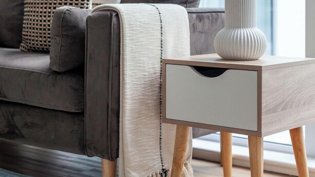 A modern living room with a grey sofa, a white side table, and a patterned rug. - The Ealing Luxury Flat (London)
