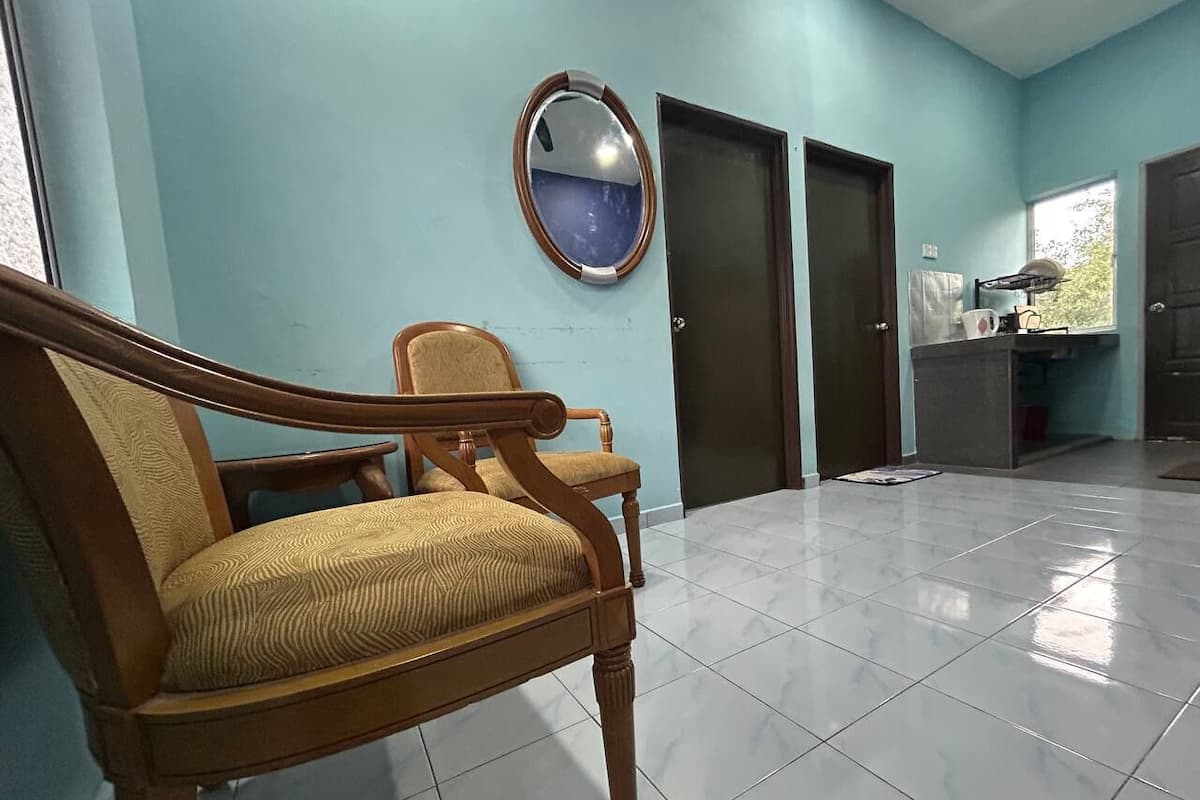 A room with a wooden chair, a round mirror, and a tiled floor.