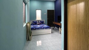 Un dormitorio con cama, ventilador de techo, aire acondicionado, puerta de madera y alfombra roja.