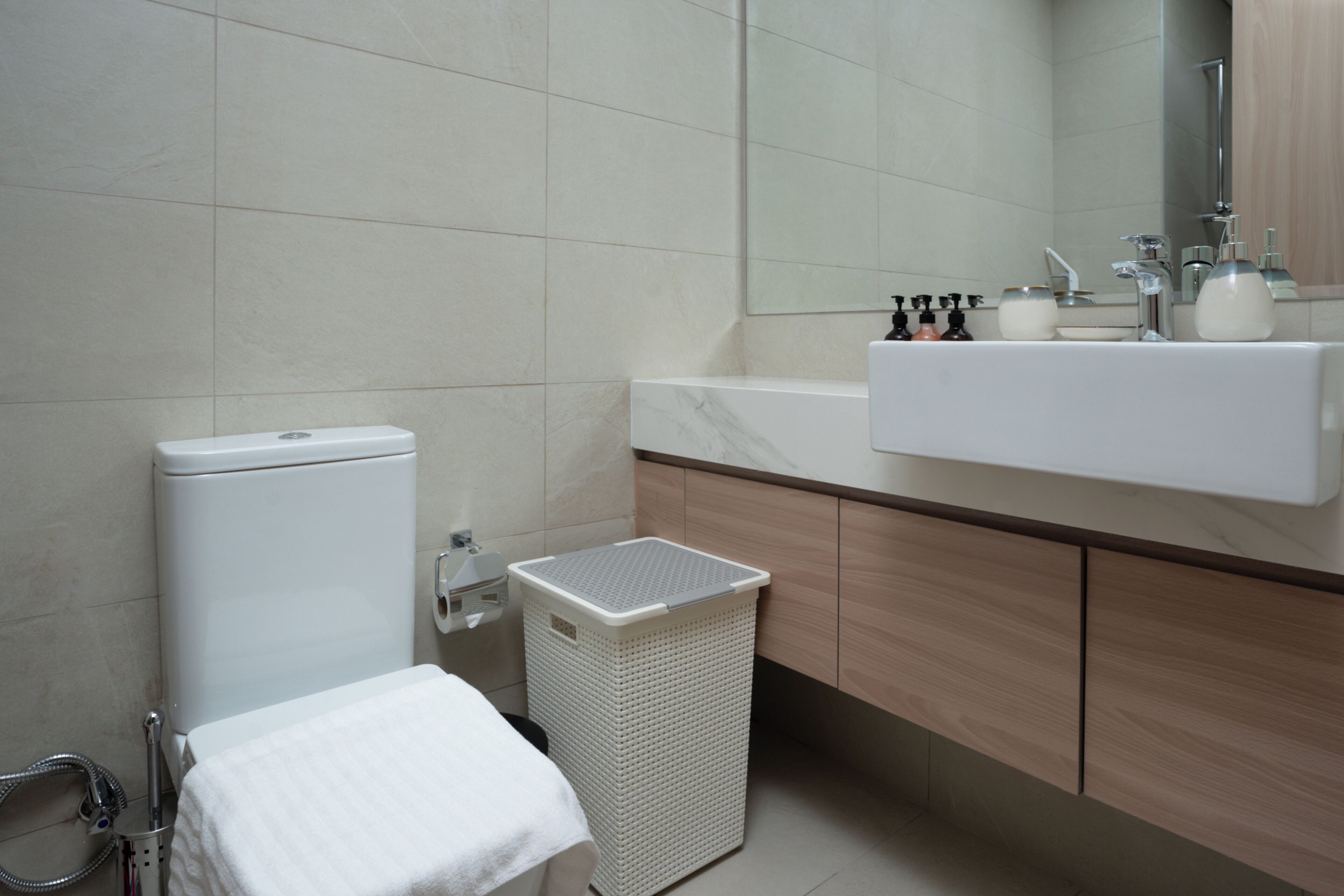 Een moderne badkamer met toilet, wastafel en spiegel.