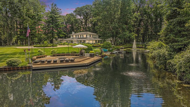 A lakeside property with a dock, lounge chairs, and a fountain. - Klinger Lake Cove - Sleeps 16-24 (White Pigeon)