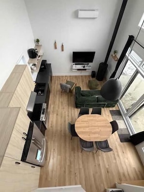 Ein zeitgemäßer Wohnraum mit Küche, Essbereich und einem großen Fenster, das für natürliches Licht sorgt.
