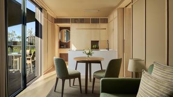A modern interior with a dining area, a kitchen, and a view of the outdoors.